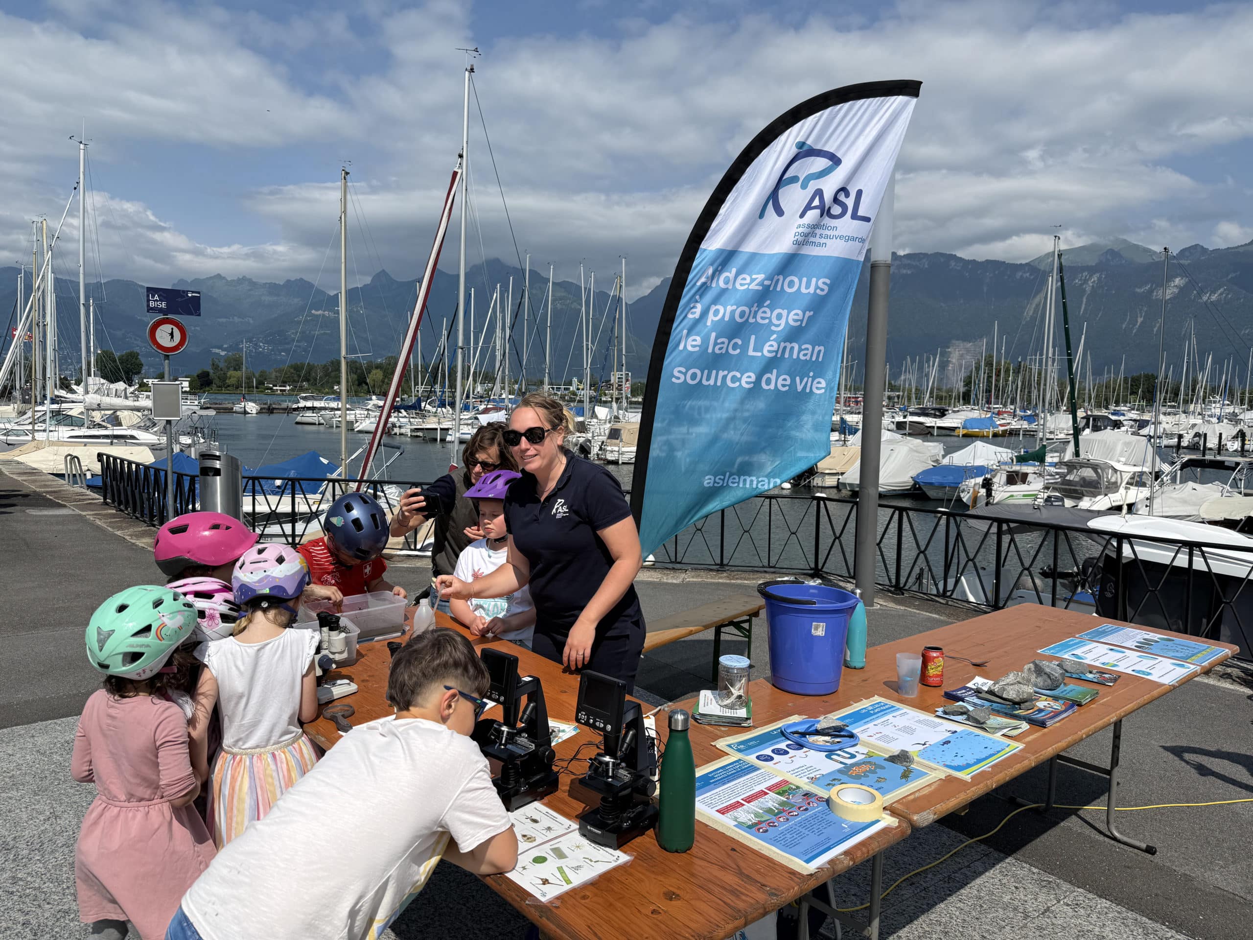 Stand de l'association pour la sauvegarde du Léman au bord du lac avec des enfants qui posent des question dur le Léman et la biodiversité